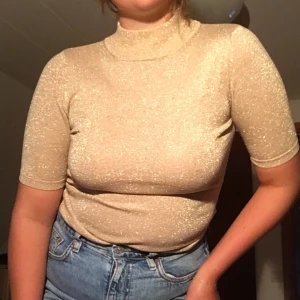 Supercool festtopp💫💫 - Gullig och glittrig festlig topp. Oväntat skön att ha på sig, strechigt material och har en gullig liten polokrage. Toppen är i jättefint skick✨