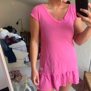 Oddmolly klänning st 1 - Rosa kort klänning med volang nedtill, passar bra som strandkläning till exempel. Nästan aldrig använd. Inga blekningar eller fläckar på! Frakt tillkommer