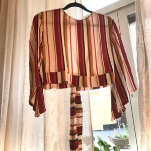 Randig blus - En randig blus från Legit som jag köpte på en resa. När jag kom hem insåg jag att den är lite liten i storleken men då va det försent att byta. Knyts i ryggen och är kort i på längden. Enbart prövad. Storleken är M men jag skulle vilja säga S/M om jag jämför med andra kläder jag äger. Möts gärna upp i Stockholm eller skickar den men då får man stå för frakten själv. 