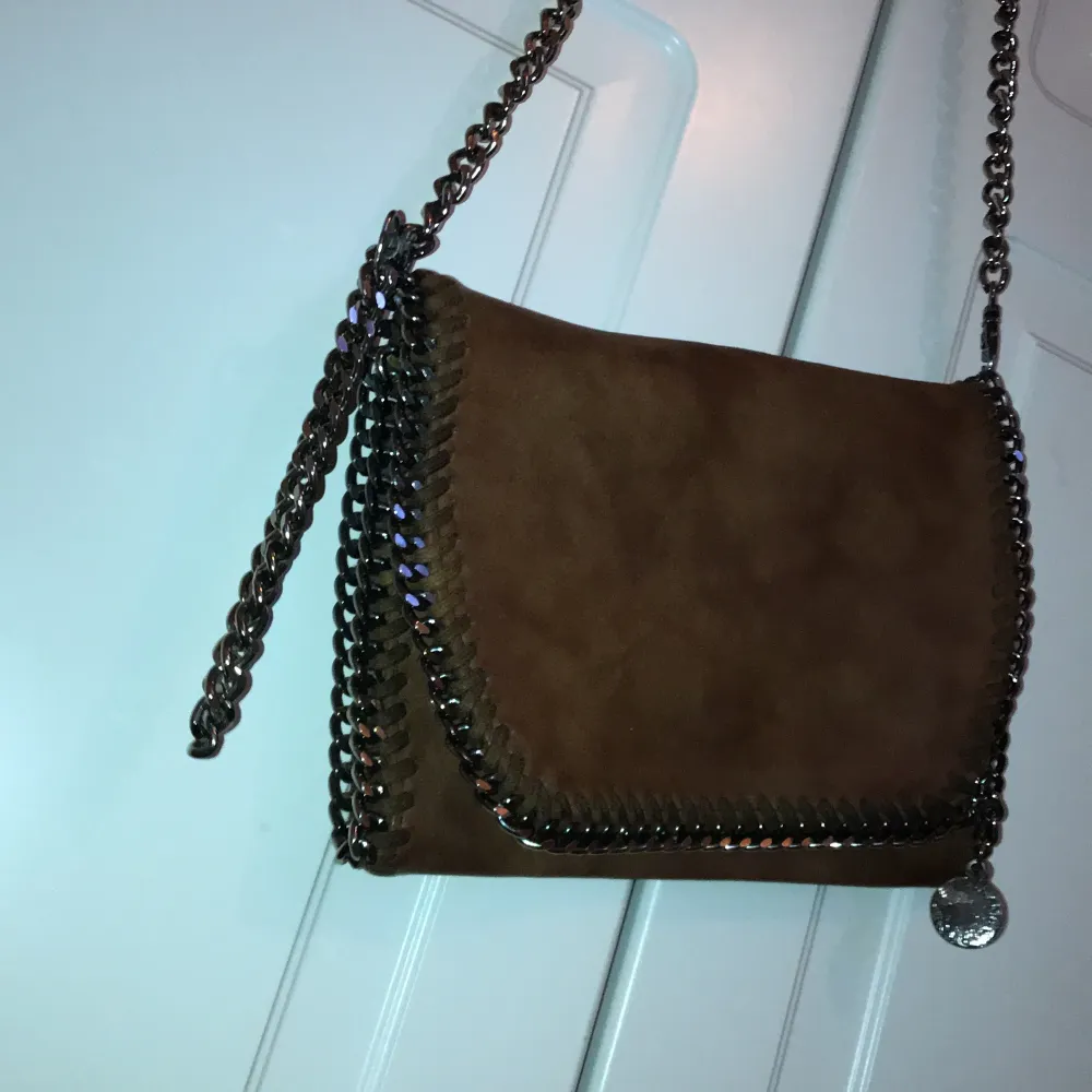 En fejk Stella McCartney-crossbody i ljusbrun färg mot det guldiga hållet köpt i Turkiet. Bra skick.. Väskor.