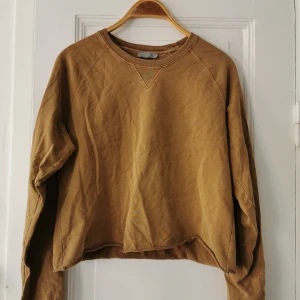 Beige croppad sweatshirt - Sweatshirt från Cos i en varm, beige nyans. Croppad men inte jättekort, kan klippas av om man vill ha den kortare.