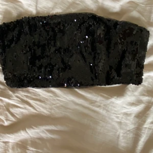 Glittrig bandaeu topp - Glittrig bandaeu topp, storlek 36, aldrig fått användning för men jättefin o ha bara så eller med någon skjorta över eller liknande. Säljer för 45 kr inkl frakt