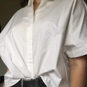 Kort vit skjorta med silverdetalj vid kragen från zaras Trafluc Collection