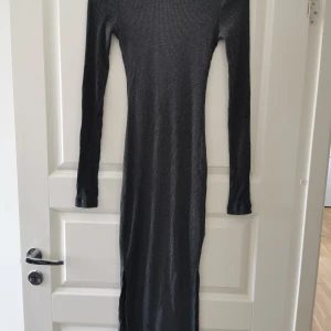 Ribbad långklänning  - Med slits på båda sidorna längst ner. Storlek s. Aldrig använd. Från nelly. 