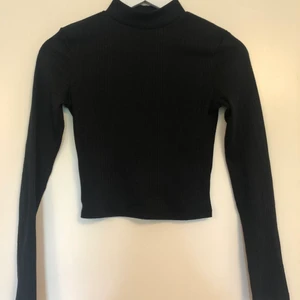 Mönstrad svart långärmad magtröja - Använd fåtal gånger. Köpt på H&M. Mönstrat tyg. Kameran tar upp färgen konstigt på andra bilden, den är helt svart. Sitter tajt.