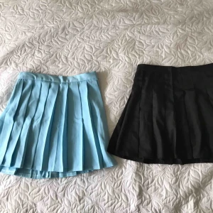 - Två kjolar💙 knappen har gått sönder på den blå kjolen men båda har en dragkedja, den svarta har inbyggda byxor, frakt tillkommer