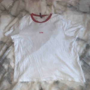  - En t-shirt som är vit och det står love på den