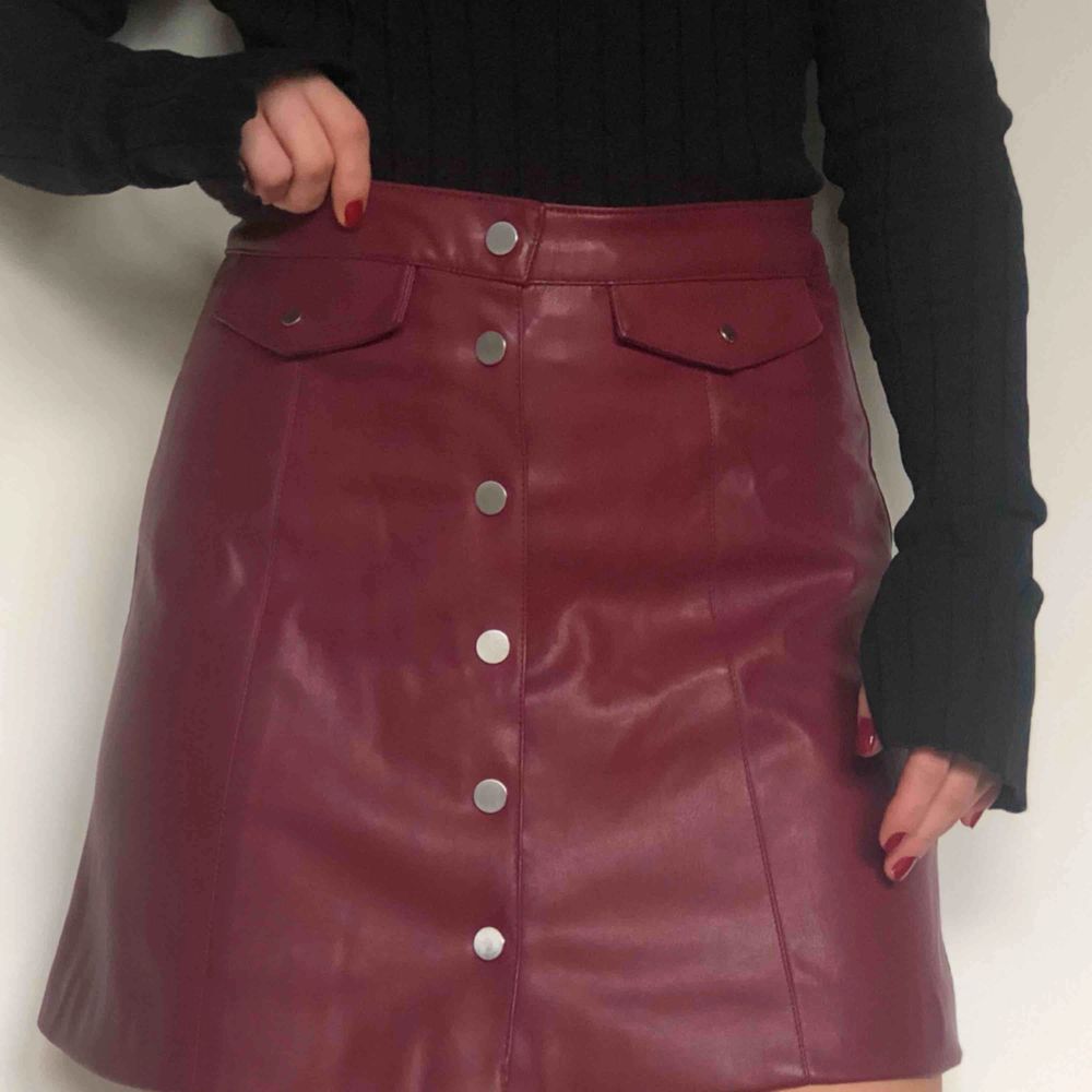 Vinröd kjol i fakeskinn från hm, oanvänd med lappen kvar då den är för stor för mig.   Köparen står för fraktkostnaden. Kjolar.
