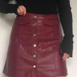Vinröd kjol i fakeskinn från hm, oanvänd med lappen kvar då den är för stor för mig.   Köparen står för fraktkostnaden