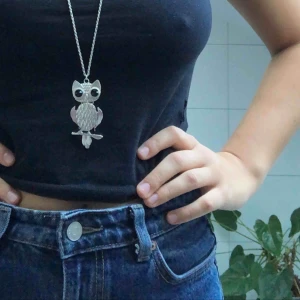  - Uggla på en silvrig kedja. Går att ställa in i olika längder. 