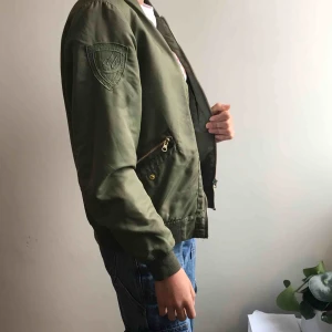  - D brand grön bomberjacka. Köpt för några är sedan. Nypris 1350. I gott skick. Hade ett hål på vänstra sidan som jag försökte laga. Har ett litet hål på högra sidan som inte syns så mycket. 