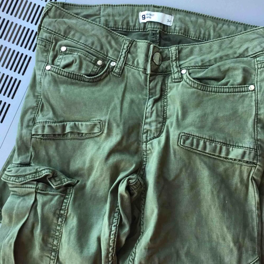 Ett par lågmidjade militär gröna jeans med ficka på ena låret. ifrån Gina tricot. Använda en gång. Köpta för 499kr med säljer för 120kr. Pris kan diskuteras!. Jeans & Byxor.
