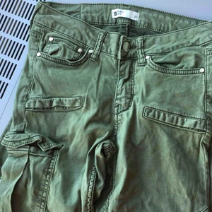  - Ett par lågmidjade militär gröna jeans med ficka på ena låret. ifrån Gina tricot. Använda en gång. Köpta för 499kr med säljer för 120kr. Pris kan diskuteras!