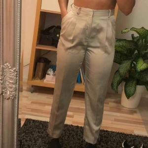  - Champagnefärgade kostymbyxor i siden. Frakt ingår