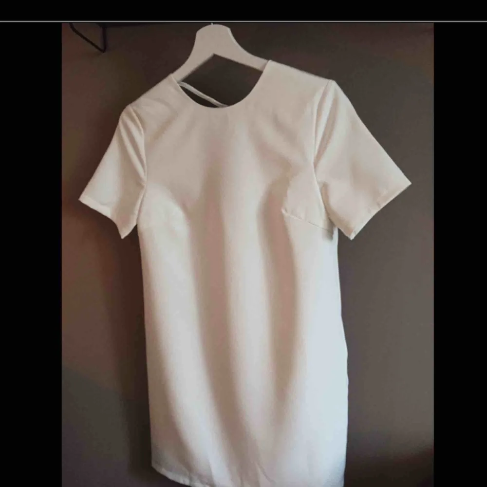 Enkel vit klänning i rak modell, köpt på Nelly.com förra året till min student, men använde den aldrig. Den är därför helt ny, endast provad. Kostade 300kr. Slutar en bit ovanför knäna på mig som är 1,63cm. Dubbelt tyg gör att den inte är genomskinlig.. Klänningar.