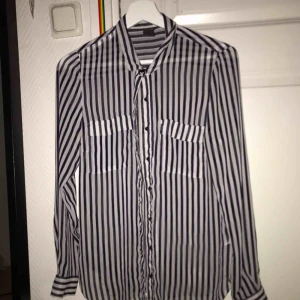  - Svart-och-vit randig blus i genomskinligt tyg Köparen står för frakt  