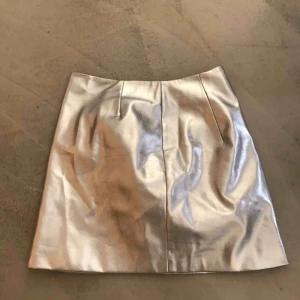  - Silvrig kort kjol från hm divided. Dragkedja i sidan