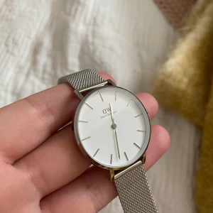 Daniel wellington klocka - En super fin silvrig Daniel wellington klocka som är i ett bra skick, då den sällan är använd! Säljer på grund av att jag inte använder mig av den! Den är som går att göra större samt mindre beroende på  ens handled.