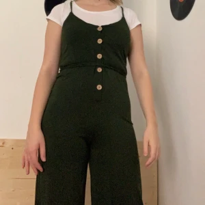 Grön jumpsuit  - Jättefin jumpsuit i grön färg perfekt till hösten! Den är i bra kvalitet. Vet inte vart den är ifrån mina föräldrar köpte den till mig när dom var utomlands. Använd ett fåtal gånger