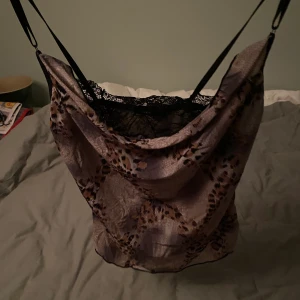 Y2k topp med spets  - Jättefint linne med mjukt silkesliknande tyg som faller som volanger vid bysten. Innanför finns en spetsdel som skyddar urringningen och ger en fin kontrast. Skulle säga att den är en XS men pga stretchigt tyg passar den mig som är S/M