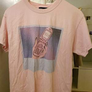 Ljusrosa T-shirt med fint tryck från reclaimed vintage. Storlek S men oversized så sitter mer som M - L