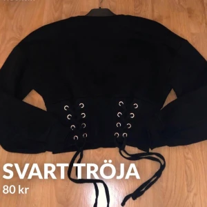 Svart tröja  - Svart tröja med knytning i midjan. Använd fåtal gånger. Mitt pris: 80kr+ frakt 