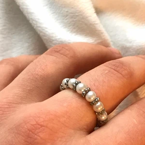 Vacker pärlring  - Ring med vackra vita silkespärlor med silvriga mini blommor mellan. Gjort i gummitråd så ringen är elastisk och passar de flesta fingrar. Alla pärlor jag använder är återvunna från secondhand. Så varje smycke är unik och av begränsat antal;) frakt 11kr