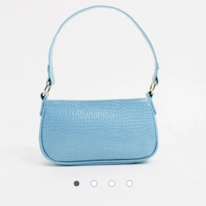 Blå väska - Säljer denna trendiga baugette bag från Asos som är slutsåld! Säljs eftersom jag har en liknade redan! Sparsamt använd så väldigt fint skick! Säljs för 150kr + 44kr i frakt!😊 