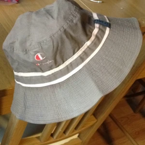  - Vuxen strl M - champion hatt  Skön hatt för varma dagar  Använd några gånger ute med båten  Snöret sitter fast i hatten men går att klippa av om så önskas. Väldigt käckt när det blåser mycket och man vill fiska. 