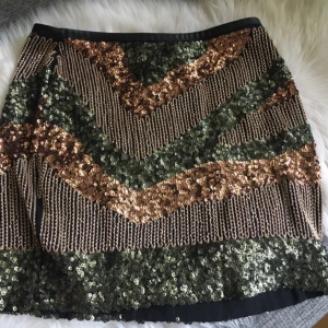  - Paljettkjol  Längden slutar strax över knäna 