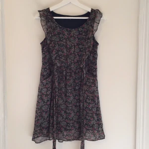 - Blommig babydoll/tea-dress i storlek 36. Köpt i en butik i London. Nytt skick. Aldrig använd. Volanger upptill, 2 fickor och band. Jättefin till vår och sommar! 