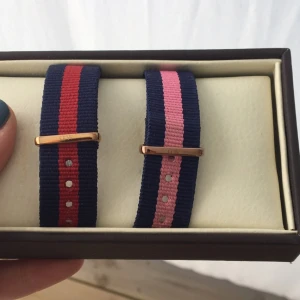  - Klockarmband till Daniel Wellington klocka i 36 mm och färgen rosé. Tar 200 för det blå/röda då det aldrig är använt och 150 för det rosa då jag använt det en del. Nypris 299:-, kan mötas upp i Växjö eller skicka om köparen står för frakt