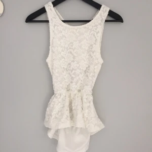  - Petite peplum top i vit spets med öppen rygg, från Bikbok. I fint använt skick. 25kr +frakt