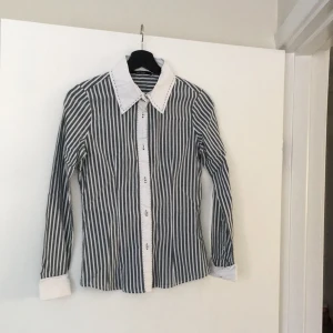  - Grå randig kontorsblus, bomull med stretch. Passar strl 36-38. Mycket bra skick.