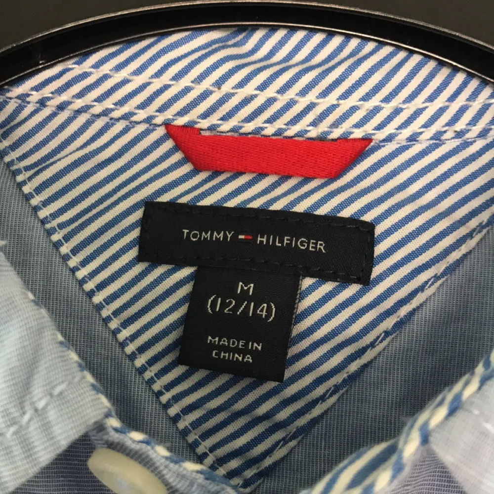 En äkta Tommy Hilfiger skjorta köpt i New York. Storleken är i åldern mellan 12-14 men passar även i XS. Går lika utmärkt att ha den till tjej som kille. Skjortor.