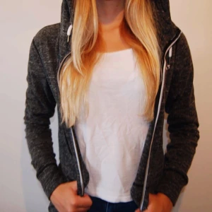  - En långärmad luvtröja i mörkgrå  Ordinarie pris 250kr 