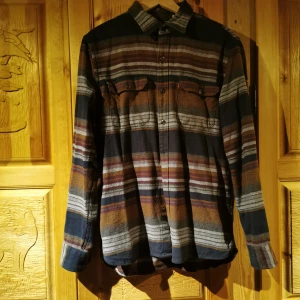 Levis skjorta flanell - Randig flanellskjorta från levis sjukt skön! Fina färger och känslan är oversize. Bilderna är ej bra tagna men vill bara få ut mina plagg, om du köper plagget tvättar jag det självklart innan! 