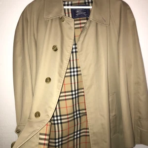 Burberry Trenchcoat - En äkta Vintage Burberry Trenchcoat i nyskick. Sitter som en L. Ett innefoder ingår även som kan fästas med dragkedja på jackan innersida - perfekt för vintern. 