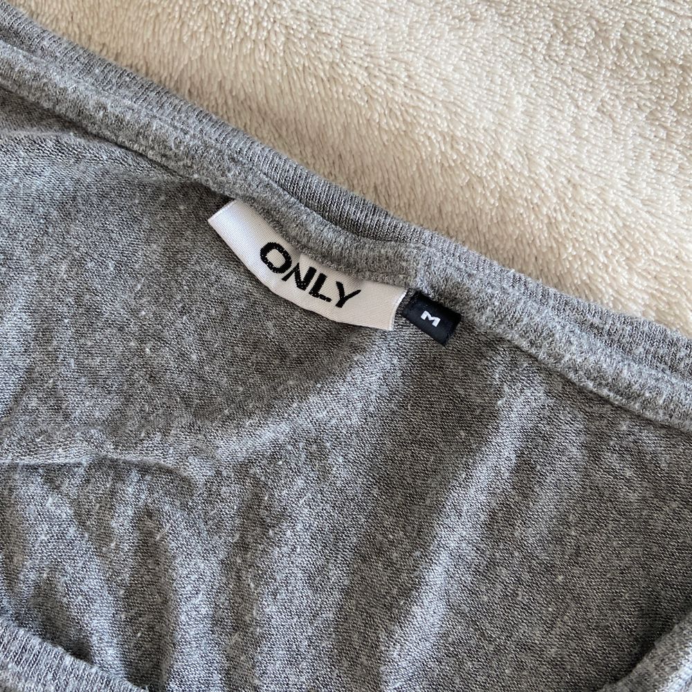 Grå t-shirt med svarta vingar där bak. Stor i storleken och väldigt pösig. Är gjord i 95% viskos och 5% elastan.. T-shirts.