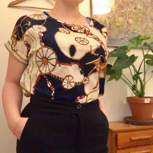  - Kortärmad blus köpt begagnad på beyond retro. Använd ett fåtal gånger och är i gott skick. Står att den är en XXL men skulle säga att den är mer av en S/M. Kan mötas upp i Stockholm eller frakta! (Köparen står för frakten)