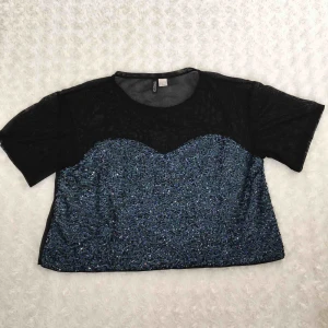  - T-shirt från H&Ms Divided med blåa paljetter. Ryggen är helsvart i ett genomskinligt material.  Använd vid ett tillfälle.  Kan mötas upp alt. skicka.