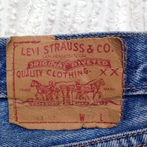  - Levisjeans, typ strl S. Har ett litet hål nedanför ena bakfickan (se bild 3) och ett pyttepytte litet hål uppe vid ena bakfickan. Annars felfria. 