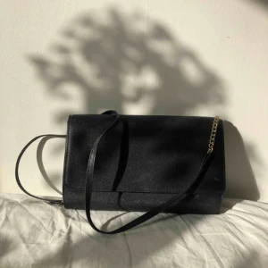  - Svart väska med detaljer i guld från H&M. Sparsamt använd!