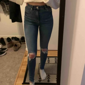 Jeans - Högmidjade jeans från Ginatricot med hål på knäna och slitningar längst ner, jättefina men kommer aldrig till användning. Endast använda 1 gång & nypris 399 kr. Om dom ska fraktas ligger frakten på 59kr