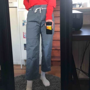  - gråa byxor med coola detaljer köpa från Weekday, i modellen Delft Pocket Trousers. Byxorna är köpta från killavdelningen och passar mig som vanligen är en S/M. Säljer på grund av att de blivit för korta, jag är 174cm lång. Frakt tillkommer!!