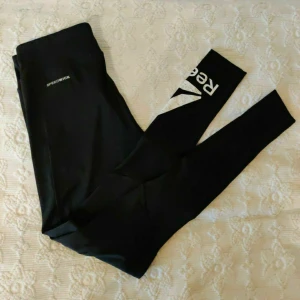Reebok träningstights NYA XS - Nya träningstights från Reebok Endast testade. Storlek XS Mesh under knäna Inga slitningar på trycket.  Fraktförslag mottages gärna. Samfraktar