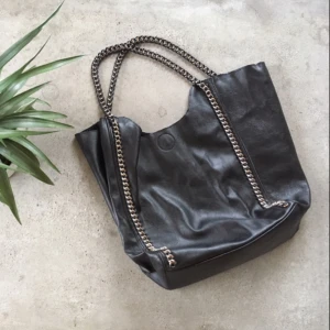  - Fin svart väska med handtag och detaljer i silver som skimrar lite åt rosé!