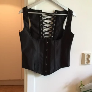  - Korsett med plastskenor, svart.