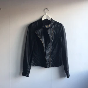  - Snygg skinnjacka med peplum nertill och med gulddetaljer