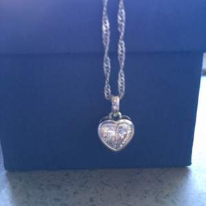 Halsband i silver med hjärtformad kristall.